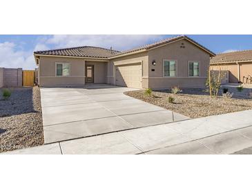 Tan single-story home featuring a concrete driveway, tile roof and low desert landscaping at 635 W Pintail Dr, Casa Grande, AZ 85122