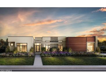 Stunning single-story modern home with diverse textures, professional landscaping, and walkway to entrance at 6521 E Paradise Dr, Scottsdale, AZ 85254