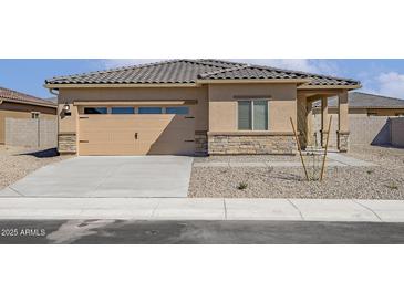 Charming single-story home with a tan exterior, a two-car garage, and low-maintenance desert landscaping at 666 W Pintail Dr, Casa Grande, AZ 85122