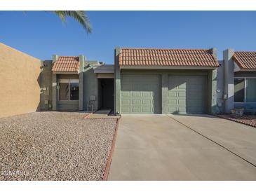 Charming single-story home featuring a two-car garage, desert landscaping, and a classic tile roof at 838 W Duke Dr, Tempe, AZ 85283