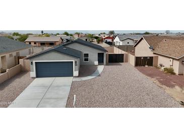 Charming single-story home featuring a two-car garage and low maintenance desert landscaping at 8852 W Swansea Dr, Arizona City, AZ 85123