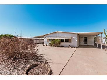 Quaint single-story home featuring a covered carport and mature desert landscaping at 106 S 74Th St, Mesa, AZ 85208