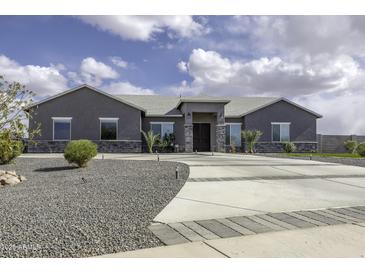 Beautiful single story home boasts an elongated driveway and lovely landscaping at 1455 E Dove Pl, Casa Grande, AZ 85122