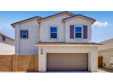 Charming two-story home featuring a stucco exterior, a two-car garage, and shutters at 14628 W Sand Hills Rd, Surprise, AZ 85387