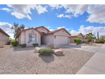 Charming home with a low maintenance desert landscape, gravel, shrubs, and a two-car garage at 2453 E Hancock Trl, Casa Grande, AZ 85194