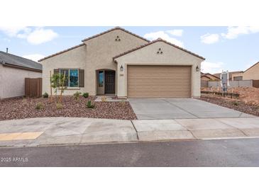 Inviting single-story home featuring a well-manicured yard and a two-car garage at 2658 N Coronado Dr, Florence, AZ 85132