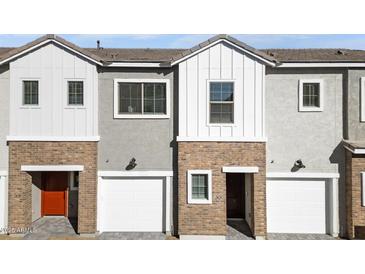 Modern townhome featuring brick and white siding with private garages at 2828 W Eagle Talon Rd, Phoenix, AZ 85085