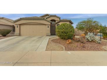 Charming single-story home featuring a two-car garage and desert landscaping at 42266 W Sparks Dr, Maricopa, AZ 85138