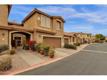 Charming townhome with desert landscaping, covered entryway, and attached two-car garage in a well-maintained community at 5415 E Mckellips Rd # 24, Mesa, AZ 85215