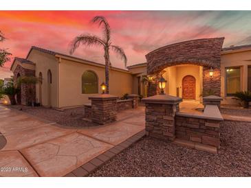 Inviting home exterior with stone accents, arched entryway, and well-manicured landscaping at 8260 N Buena Vista Dr, Casa Grande, AZ 85194