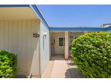 Inviting front entrance featuring a charming walkway and well-maintained landscaping at 10859 W Coggins Dr, Sun City, AZ 85351