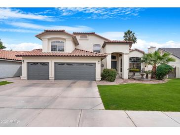 Two-story stucco home featuring a tile roof, well-manicured lawn, and a spacious three-car garage at 1225 E Sea Gull Dr, Gilbert, AZ 85234
