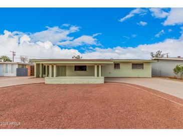 Charming single-story home featuring a large, gravel-covered front yard and an inviting covered porch at 1238 E Barcelona Ave, Casa Grande, AZ 85122