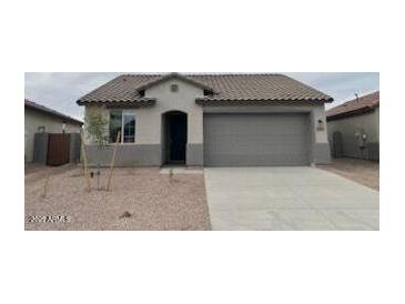 Charming single-story home featuring a low-maintenance front yard, two-car garage, and neutral color scheme at 25170 W Wayland Dr, Buckeye, AZ 85326