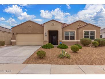 Charming single-story home featuring desert landscaping, a neutral color palette, and a two-car garage at 30303 W Whitton Ave, Buckeye, AZ 85396