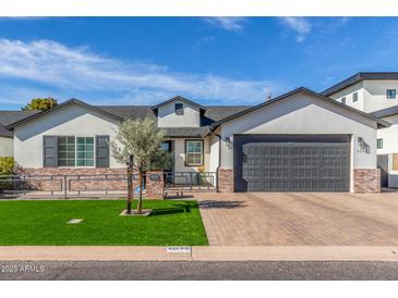 Charming single-story home featuring a well-manicured lawn, brick accents, and a spacious two-car garage at 4846 E Piccadilly Rd, Phoenix, AZ 85018