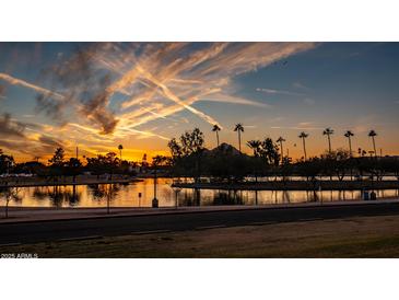 Scenic sunset view of a community lake with palm trees and iconic mountain in the background at 5046 N 81St St, Scottsdale, AZ 85250