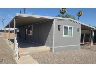 Charming gray home with a covered carport offers shade and protection from the elements at 5201 W Camelback Rd # A7, Phoenix, AZ 85031