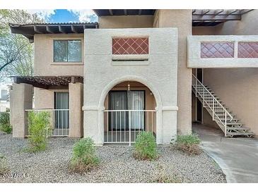 Charming condo building featuring stucco walls, arched entryways, a staircase, and desert landscaping at 5757 W Eugie Ave # 1102, Glendale, AZ 85304