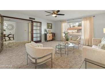 Bright living room featuring neutral color palette, plush carpet, and natural light from large windows at 6217 E El Paso St, Mesa, AZ 85205
