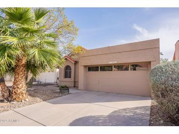 Charming single-story home featuring desert landscaping, a two-car garage, and neutral tones at 11381 E Poinsettia Dr, Scottsdale, AZ 85259