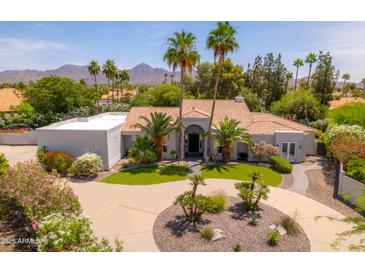 Stunning single-story home featuring mature landscaping, a circular driveway, and mountain views at 12755 N 99Th Pl, Scottsdale, AZ 85260