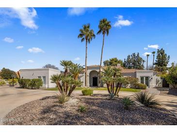 Beautiful home with circular driveway, palm trees and desert landscaping in Scottsdale, Arizona at 12755 N 99Th Pl, Scottsdale, AZ 85260