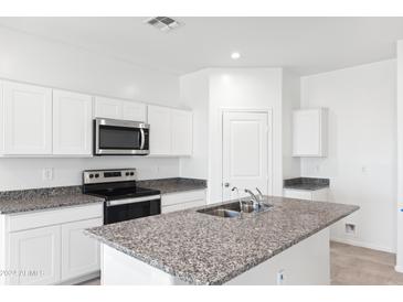 Bright kitchen with stainless steel appliances and gray granite countertops at 1345 S Vista Ave, Florence, AZ 85132