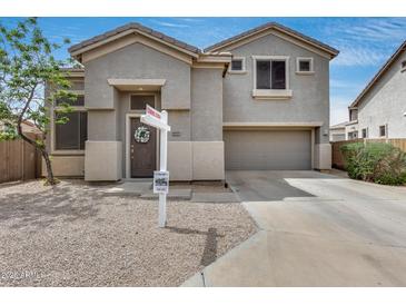 Charming two-story home featuring a desert landscape, a 'coming soon' sign and a two-car garage at 14333 W Lexington Ave, Goodyear, AZ 85395