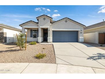 Charming single-story home with a gray garage door, neutral stucco, and low-maintenance desert landscaping at 17813 W Mission Ln, Waddell, AZ 85355