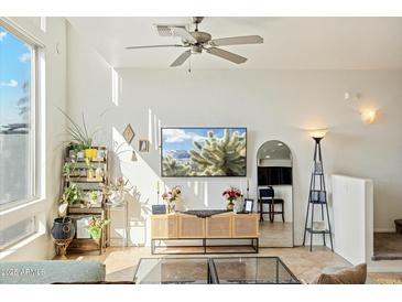 Bright living room featuring a ceiling fan, modern décor, and large windows showcasing a scenic view at 1821 W Vermont Ave, Phoenix, AZ 85015
