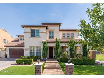 Charming two-story home with a well-manicured front yard and a beautiful brick pathway leading to the entrance at 20311 E Stonecrest Dr, Queen Creek, AZ 85142