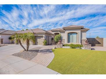 Stunning single-story home boasts lush turf, mature landscaping, and gated entry at 3948 E Vallejo Dr, Gilbert, AZ 85298