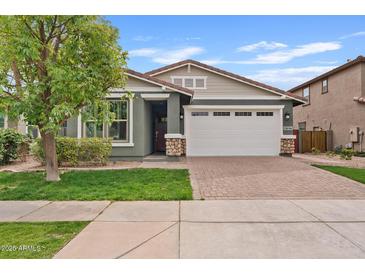 Charming single-story home with a two-car garage, neat landscaping, and a brick driveway at 4197 E Rawhide St, Gilbert, AZ 85296