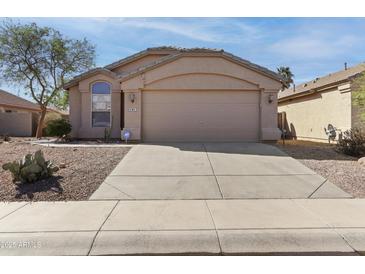 Inviting single-story home with a well-manicured desert landscape and neutral color palette at 43815 W Cahill Dr, Maricopa, AZ 85138