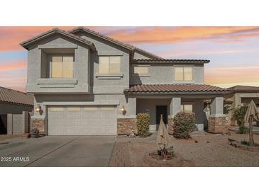 Charming two-story home featuring a two-car garage, desert landscaping, and a welcoming front porch at 7038 W Beverly Rd, Laveen, AZ 85339