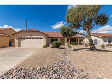 Charming single-story home with a well-manicured xeriscaped front yard and a mature shade tree at 12826 S 40Th Pl, Phoenix, AZ 85044