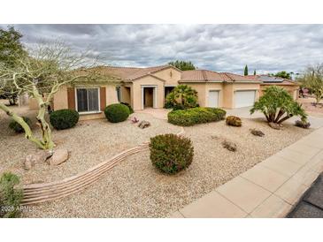 Charming single-story home with a well-manicured desert-landscaped front yard and a three-car garage at 17218 W Mahogany Way, Surprise, AZ 85387