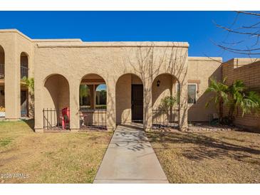 Charming facade with arched entries, secure wrought iron details, and well-manicured front yard at 2112 E Minton Dr, Tempe, AZ 85282