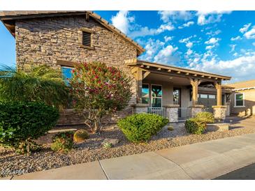 Charming single Gathering home featuring stone accents, covered porch, and mature trees at 3110 E Cat Balue Dr, Phoenix, AZ 85050