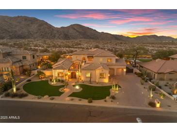 Stunning sunset view of an estate home featuring desert landscaping, a grand entrance and multiple garage bays at 3616 E Kachina Dr, Phoenix, AZ 85044