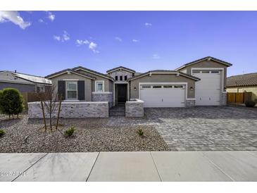 Charming single-story home featuring a three-car garage and stone accents at 40481 W Desert Fairways Dr, Maricopa, AZ 85138