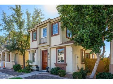 Charming two-story home featuring a light stucco exterior, brown trim, landscaped yard, and inviting entrance at 10219 E Isleta Ave, Mesa, AZ 85209