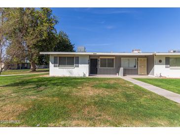 Charming single-story home with a well-maintained lawn and a welcoming front entrance at 10392 W Deanne Dr, Sun City, AZ 85351