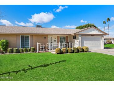 Charming single-story home featuring a well-maintained lawn, decorative fence, and a cozy, inviting entrance at 10611 W Camelot Cir, Sun City, AZ 85351