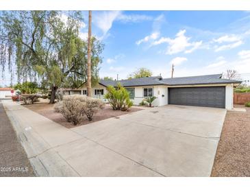 Charming single-story home featuring a spacious driveway, mature trees, and a well-maintained landscape at 1509 W Tuckey Ln, Phoenix, AZ 85015