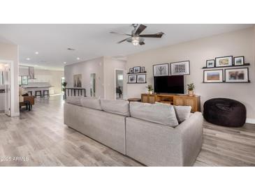 Bright and airy living room featuring wood floors, comfortable seating, and a modern ceiling fan at 1841 E Clarendon Ave, Phoenix, AZ 85016