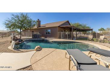 Private backyard oasis featuring sparkling pool with rock waterfall and a covered patio at 3720 E Vista Grande --, San Tan Valley, AZ 85140