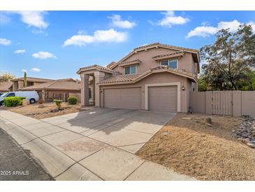 Two-story home featuring a neutral stucco exterior, tile roof, and a spacious three-car garage at 4607 E Rancho Laredo Dr, Cave Creek, AZ 85331