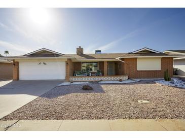 Charming single-story home featuring a well-maintained front yard with desert landscaping and a covered porch at 518 S Racine --, Mesa, AZ 85206